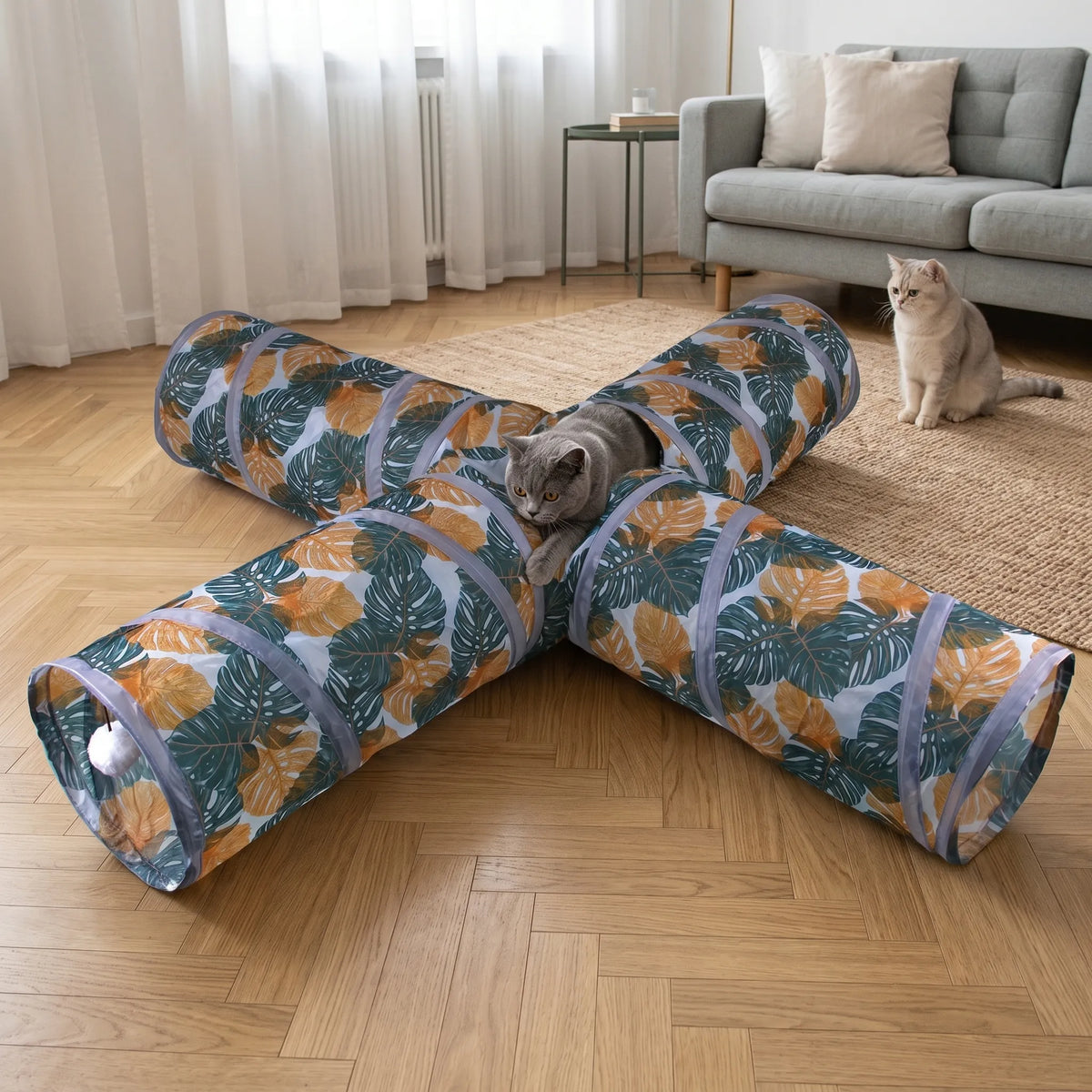 Deux chats partageant une séance de jeu avec le tunnel croisé, l'un d'eux observant depuis l'ouverture centrale supérieure.